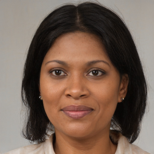 Joyful black young-adult female with medium  brown hair and brown eyes