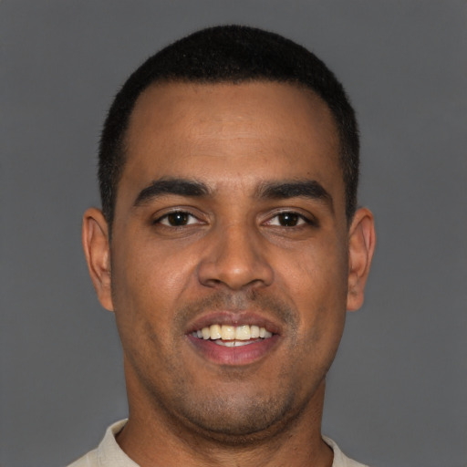 Joyful black young-adult male with short  black hair and brown eyes