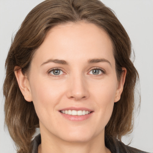 Joyful white young-adult female with medium  brown hair and grey eyes