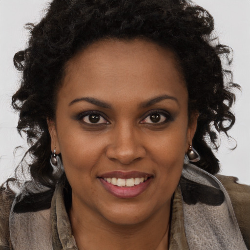 Joyful black young-adult female with long  brown hair and brown eyes