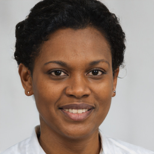 Joyful black young-adult female with short  black hair and brown eyes