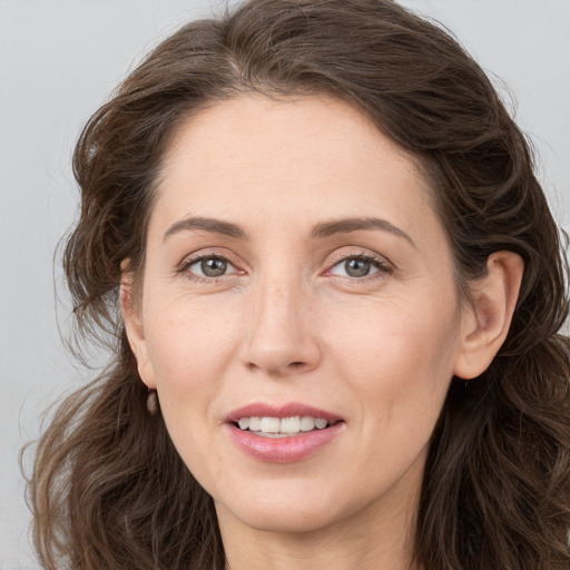 Joyful white young-adult female with long  brown hair and grey eyes