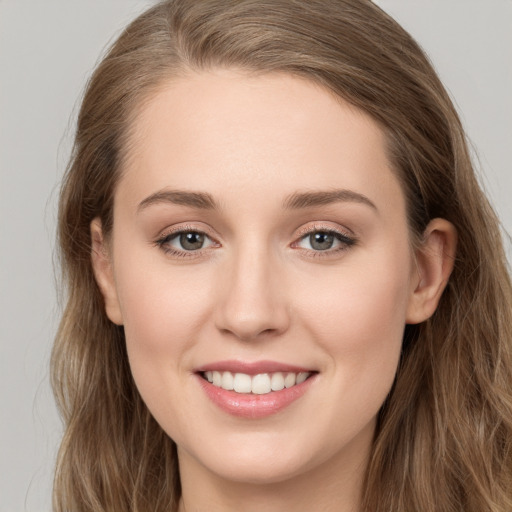 Joyful white young-adult female with long  brown hair and grey eyes