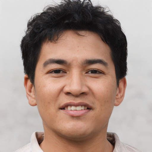 Joyful asian young-adult male with short  brown hair and brown eyes