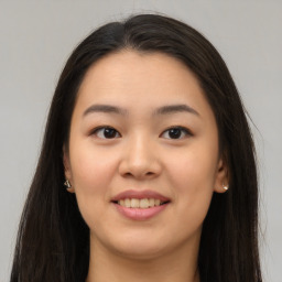 Joyful asian young-adult female with long  brown hair and brown eyes