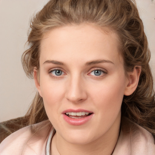 Joyful white young-adult female with long  brown hair and blue eyes