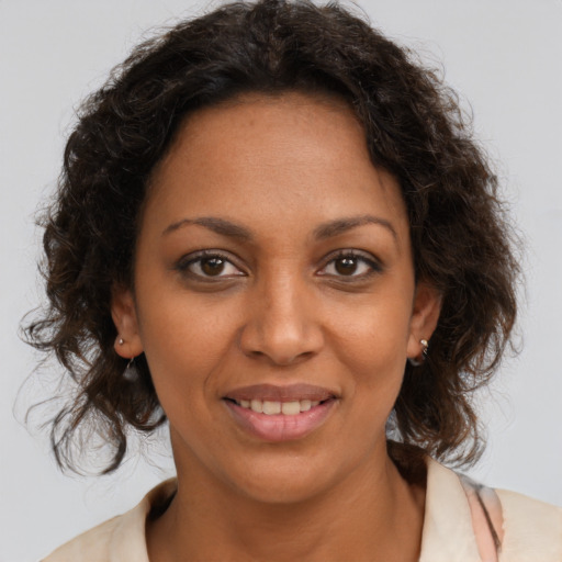 Joyful black adult female with medium  brown hair and brown eyes