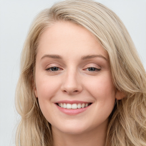 Joyful white young-adult female with long  brown hair and blue eyes