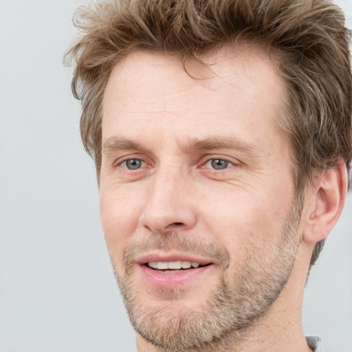 Joyful white adult male with short  brown hair and grey eyes