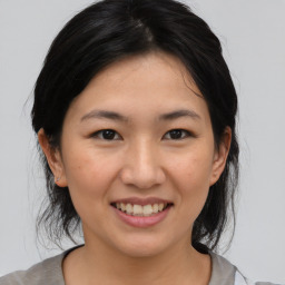 Joyful asian young-adult female with medium  black hair and brown eyes