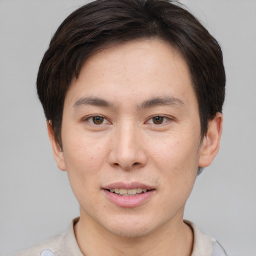 Joyful asian young-adult male with short  brown hair and brown eyes