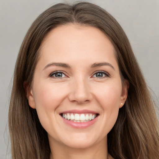 Joyful white young-adult female with long  brown hair and brown eyes