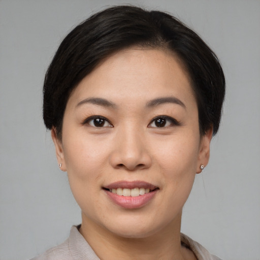Joyful asian young-adult female with short  black hair and brown eyes