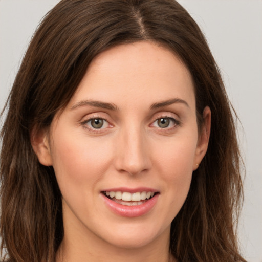 Joyful white young-adult female with long  brown hair and green eyes