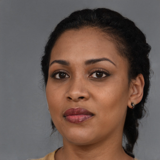 Joyful black young-adult female with long  black hair and brown eyes