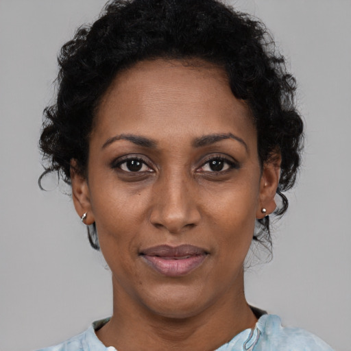 Joyful black adult female with short  black hair and brown eyes