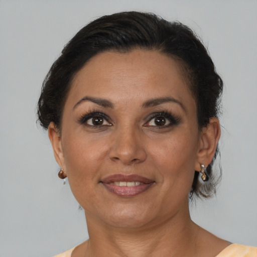 Joyful latino adult female with medium  brown hair and brown eyes