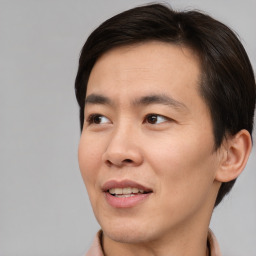 Joyful asian young-adult male with short  brown hair and brown eyes