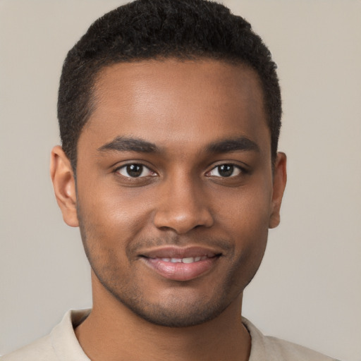 Joyful black young-adult male with short  brown hair and brown eyes