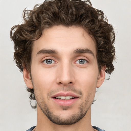 Joyful white young-adult male with short  brown hair and green eyes