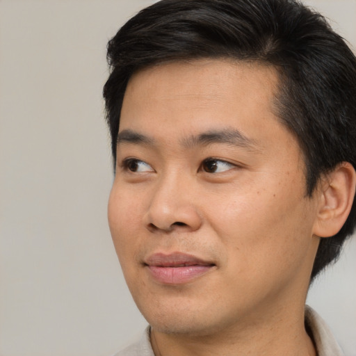 Joyful asian young-adult male with short  black hair and brown eyes