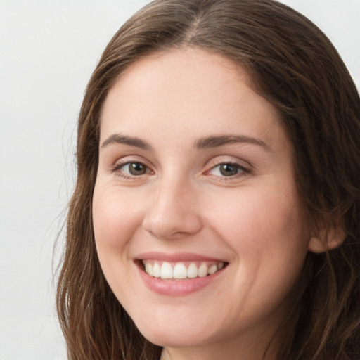 Joyful white young-adult female with long  brown hair and green eyes