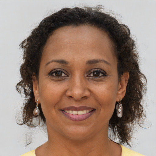 Joyful black adult female with medium  brown hair and brown eyes