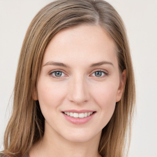 Joyful white young-adult female with long  brown hair and green eyes