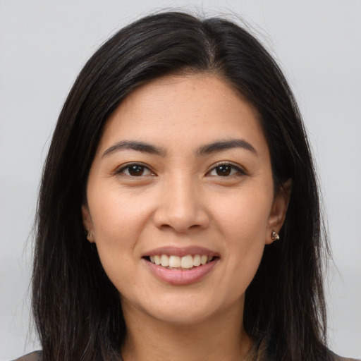 Joyful latino young-adult female with long  brown hair and brown eyes