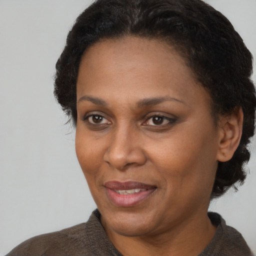 Joyful black adult female with short  brown hair and brown eyes