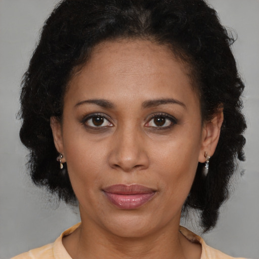 Joyful latino adult female with medium  brown hair and brown eyes