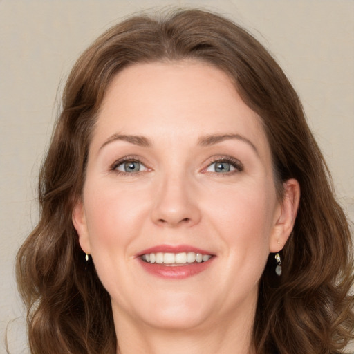 Joyful white adult female with long  brown hair and green eyes