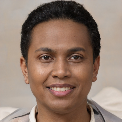 Joyful black young-adult male with short  brown hair and brown eyes