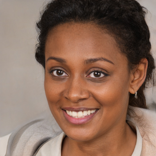 Joyful black young-adult female with short  brown hair and brown eyes