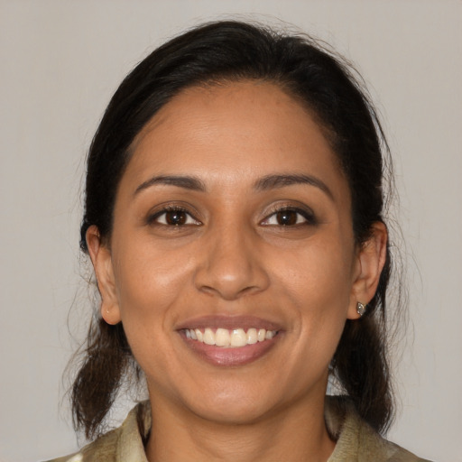 Joyful latino young-adult female with medium  brown hair and brown eyes