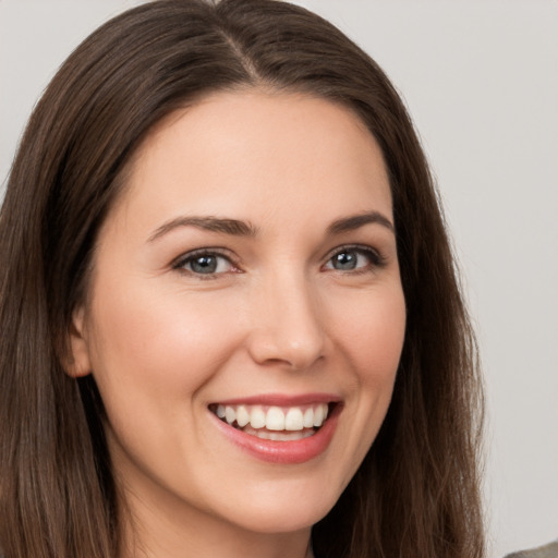 Joyful white young-adult female with long  brown hair and brown eyes