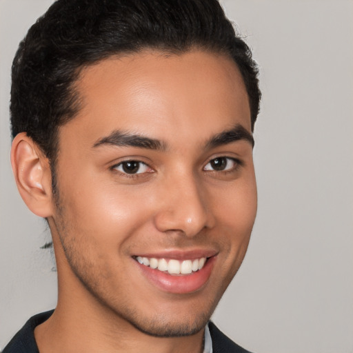 Joyful latino young-adult male with short  brown hair and brown eyes