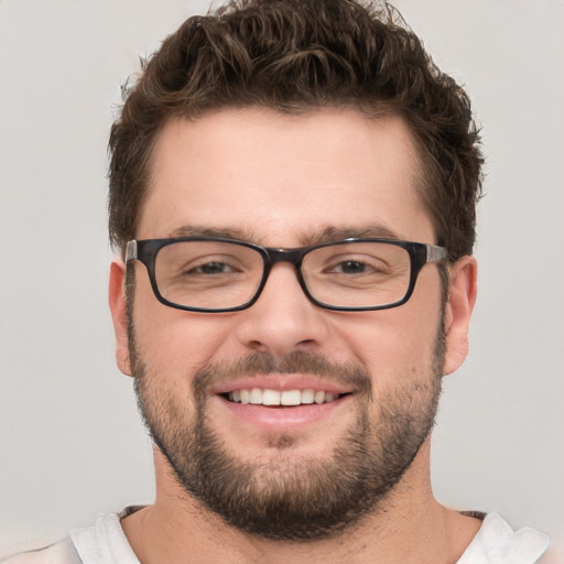 Joyful white young-adult male with short  brown hair and green eyes