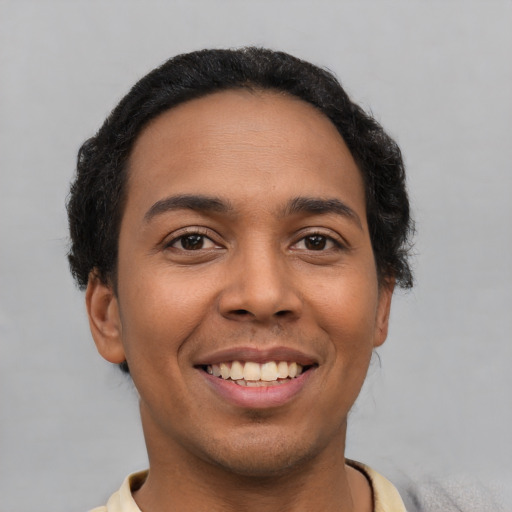 Joyful latino young-adult male with short  black hair and brown eyes