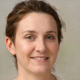 Joyful white young-adult female with medium  brown hair and green eyes