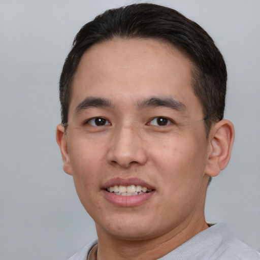 Joyful white young-adult male with short  black hair and brown eyes