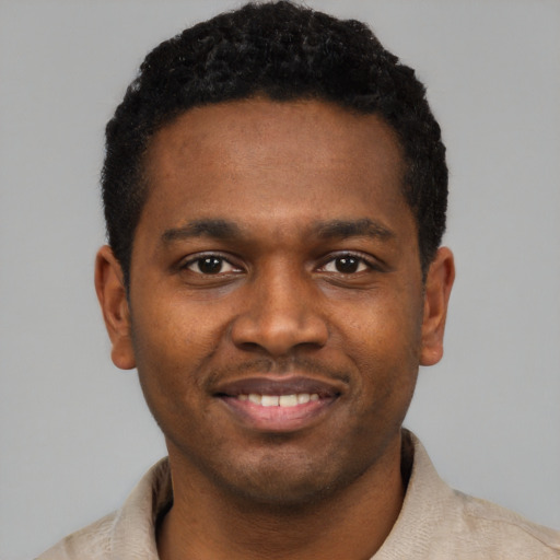 Joyful black young-adult male with short  black hair and brown eyes