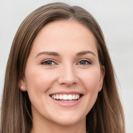 Joyful white young-adult female with long  brown hair and grey eyes