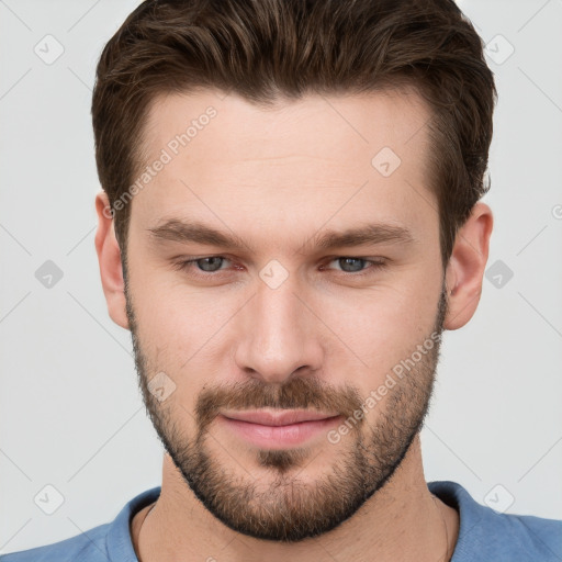 Joyful white young-adult male with short  brown hair and grey eyes