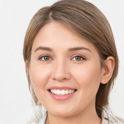 Joyful white young-adult female with medium  brown hair and grey eyes