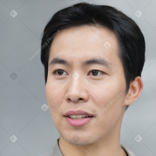 Joyful asian young-adult male with short  black hair and brown eyes