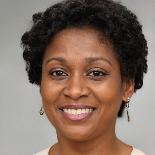 Joyful black adult female with short  brown hair and brown eyes