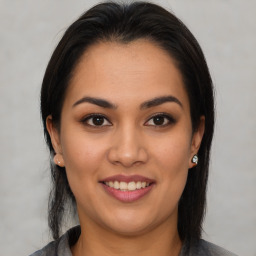 Joyful latino young-adult female with medium  brown hair and brown eyes