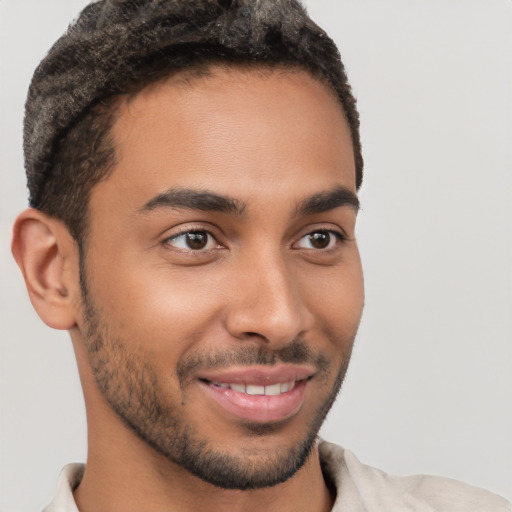 Joyful latino young-adult male with short  brown hair and brown eyes