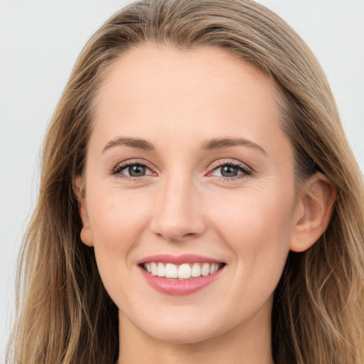 Joyful white young-adult female with long  brown hair and blue eyes